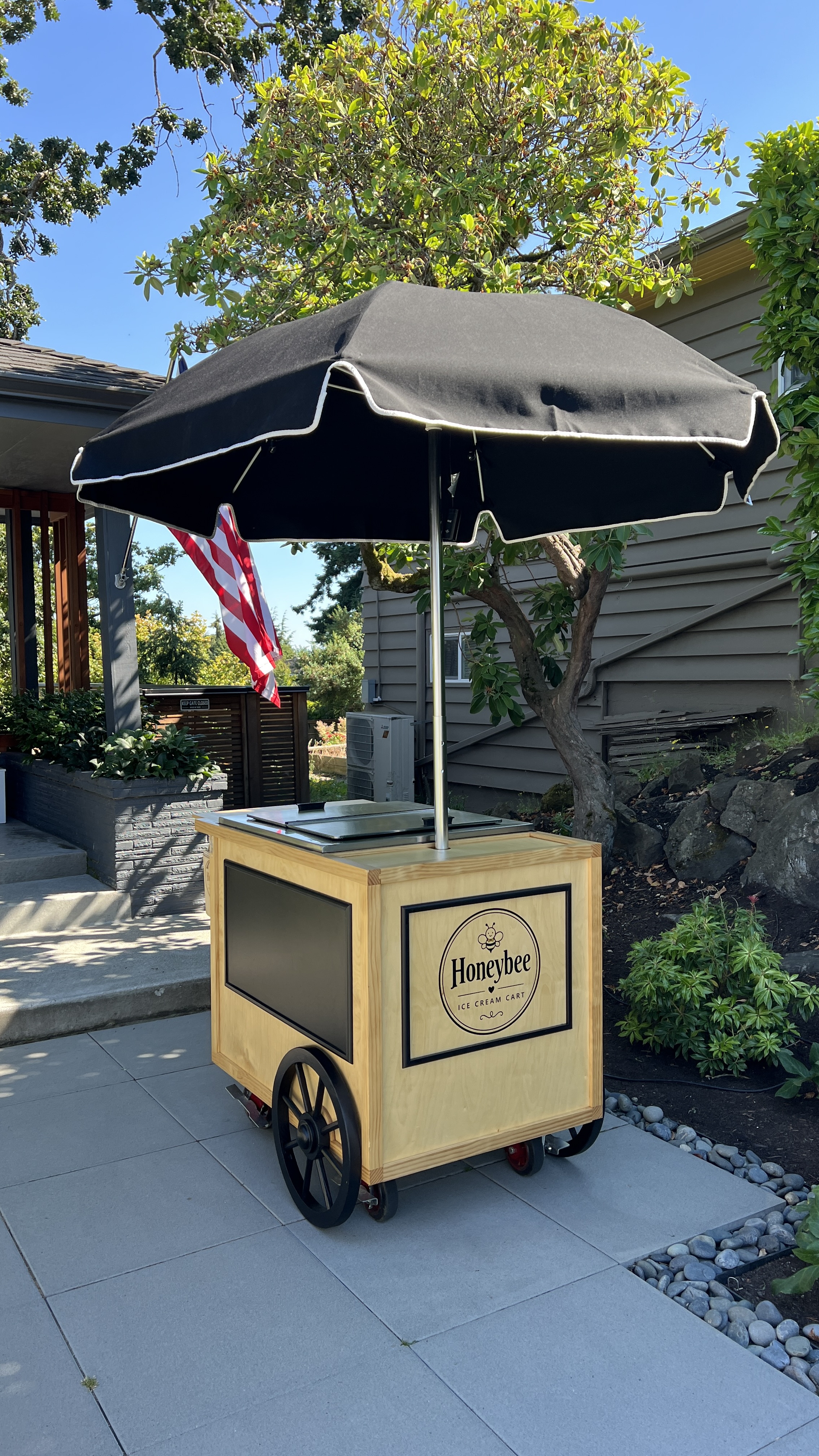 HoneyBee cart with umbrella outside a home